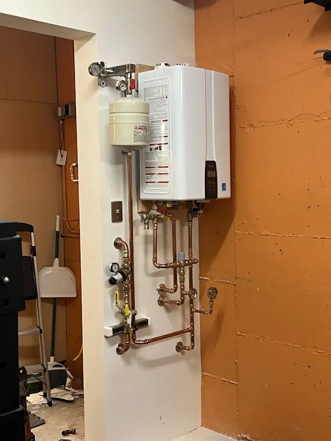Plumbing technician inspecting water heater connections in Shenandoah